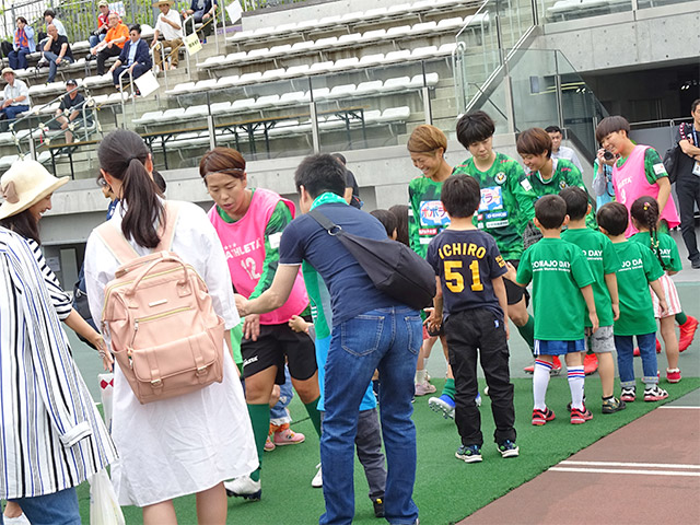 選手たちをハイタッチで迎える学園関係者